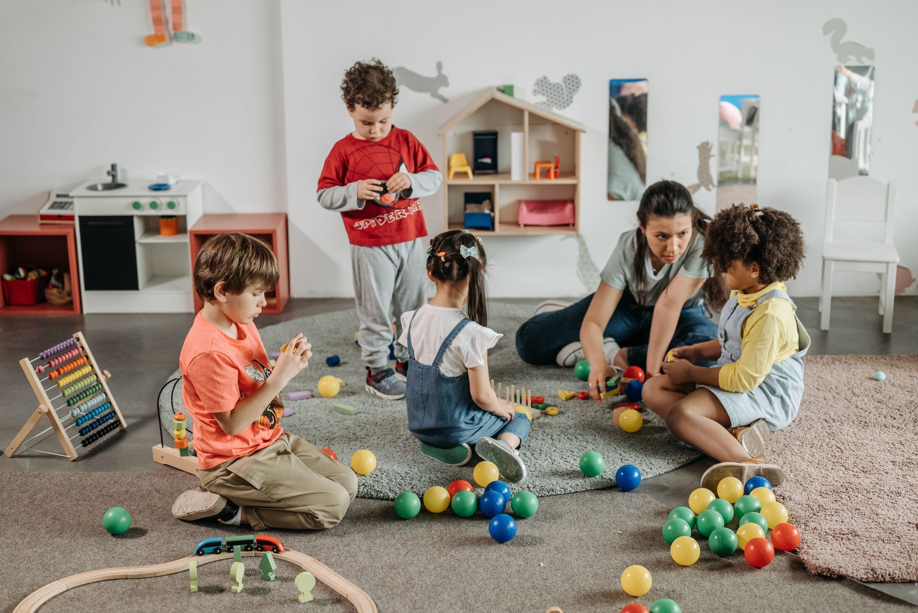 Children playing in a classroom with a teacher